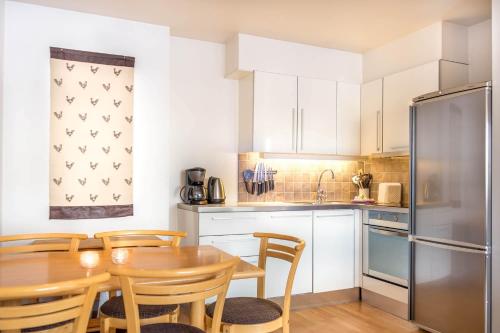 a kitchen with a table and chairs and a refrigerator at Geilolia Ferieleiligheter in Geilo