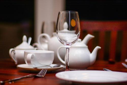a wine glass sitting on a table with a tea set at Weleges Place in Hikkaduwa