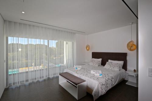 ヴィラモウラにあるVilla Pinheiro 84- Clever Detailsのベッドルーム1室(ベッド1台、大きな窓付)