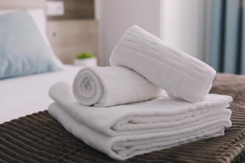 stos ręczników leżący na łóżku w obiekcie ConK Apartments by CasaTuristica w mieście Ronda