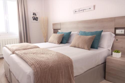 sypialnia z dużym białym łóżkiem z dwiema poduszkami w obiekcie ConK Apartments by CasaTuristica w mieście Ronda
