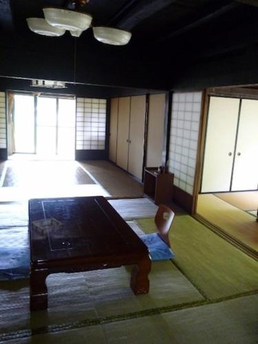 a room with a table and a chair in it at Minshuku Yurika in Urugi