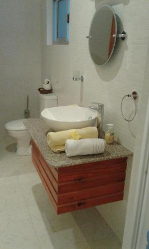 a bathroom with a sink and a mirror on a counter at Jbillaselfcatering in Beau Vallon