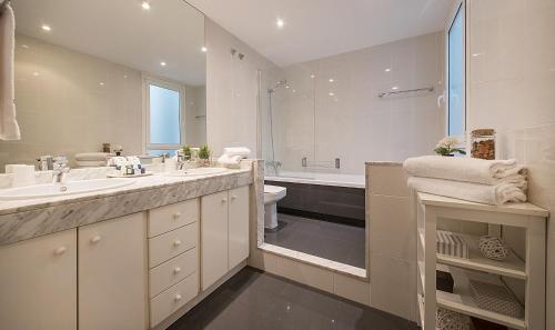 a bathroom with two sinks and a toilet and a tub at You Stylish The Most Luxury Apartment in Barcelona