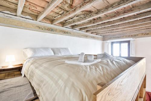 トリノにあるLoft dei Mercantiの木製の天井のベッドルーム1室(大型ベッド1台付)