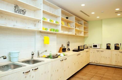 a large kitchen with white cabinets and a sink at You&I Guesthouse in Jeju