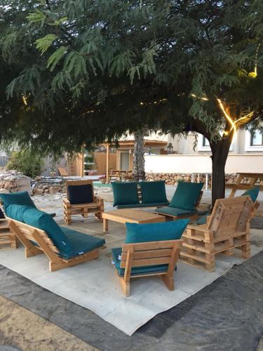 a group of chairs and tables under a tree at Tamar's House in Arad