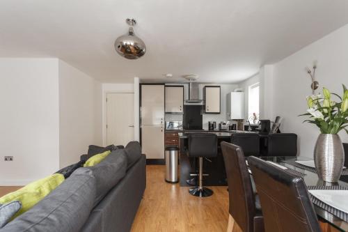 a living room and kitchen with a couch and a table at Stunning Contemporary Apartment - Free Parking - 5 Minute Walk To The Beach - Great Location - Fast WiFi - Smart TV With Netflix Included - Contractor Friendly - Perfect For Short and Long Stays in Bournemouth