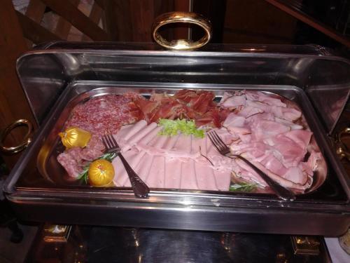 a tray of food with fork and knife and meat at Alte Schreinerei-Auberge Harlekin in Singen