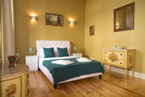 リスボンにあるTiles of São Pauloのベッドルーム1室(緑の毛布とテーブル付きのベッド1台付)