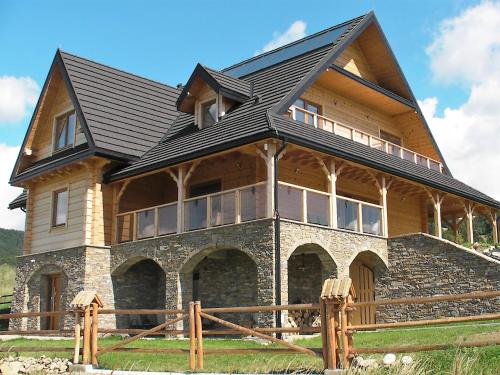 a large wooden house with a black roof at Willa Grywałd in Grywałd