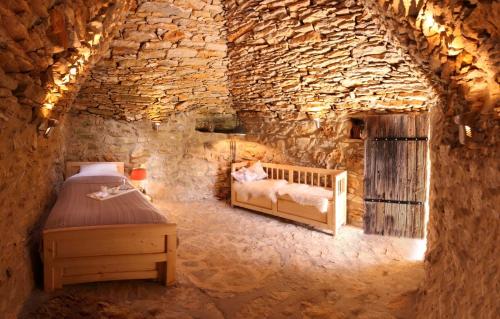 une chambre avec un lit dans un mur de pierre dans l'établissement Wild boar mountain, South of France very private and pool, à Bédarieux