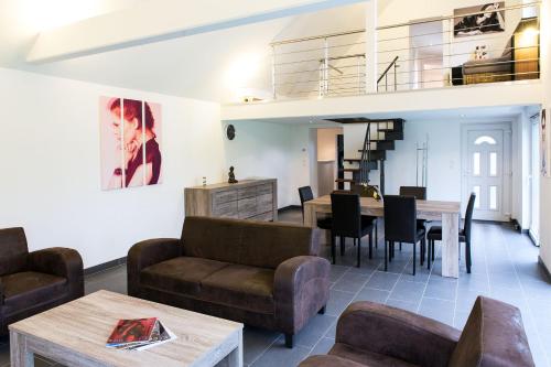 a living room with a couch and a table at SFK -Maison Moderne-Jardin-Parking-10mn Strasbourg in Vendenheim