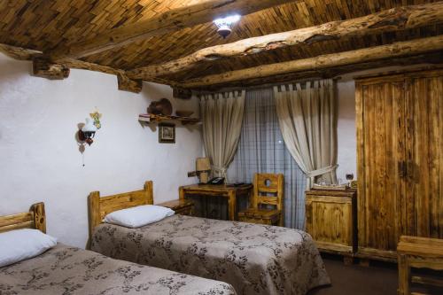 a bedroom with two beds and wooden ceilings at Pidkova in Rivne
