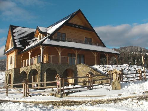 Casa de madera grande con nieve en el suelo en Willa Grywałd, en Grywałd