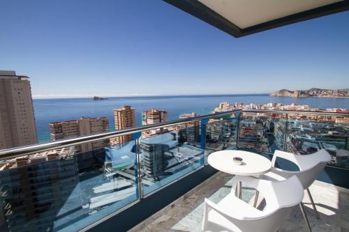 a balcony with a white table and chairs and the ocean at Hotel Madeira Centro in Benidorm