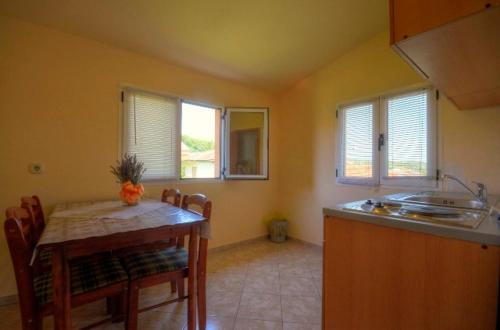 a kitchen with a table and a sink and a counter top at Apartments Jerković in Stari Grad