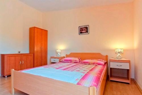 a bedroom with a large bed with two night stands at Apartments Jerković in Stari Grad