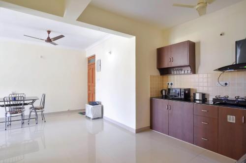 a kitchen with brown cabinets and a table in a room at Calvin's Retreat in Varca