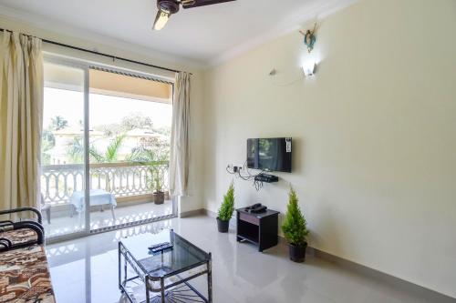 a living room with a tv and a balcony at Calvin's Retreat in Varca