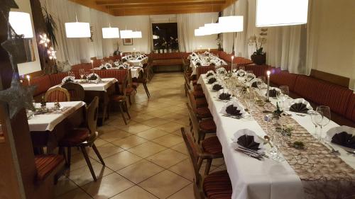 una fila de mesas en un restaurante con mesas blancas en gasthof pension rössl, en Nova Ponente