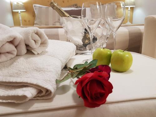 una mesa con toallas y dos manzanas y dos rosas en Hotel Aurora, en Vallarsa