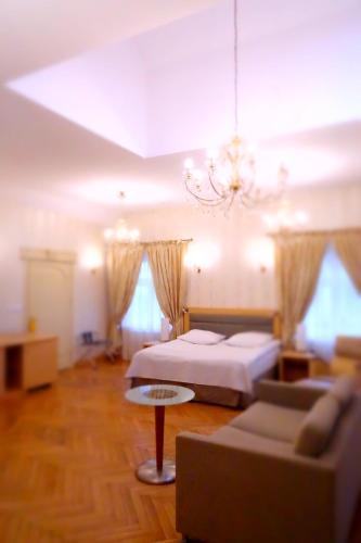 a bedroom with a bed and a couch and a chandelier at Noclegi U Kawalca in Szczecinek