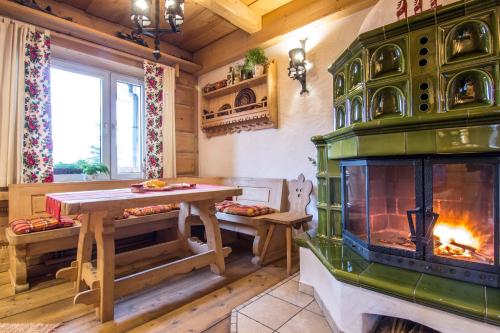 a living room with a fireplace and a table and a stove at Apartament Kominkowy Deluxe Zakopane in Zakopane