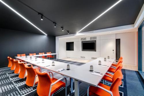 a conference room with a long table and orange chairs at Apex City of Bath Hotel in Bath