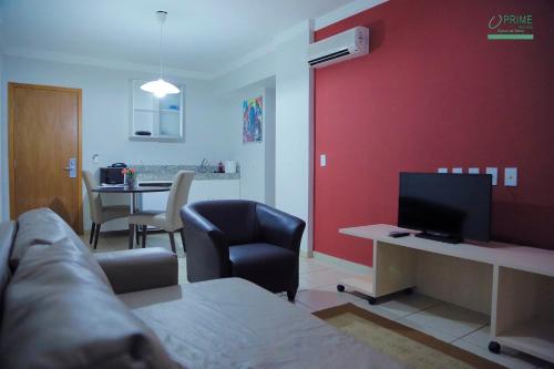 a living room with a couch and a desk with a television at Prime Hotel Águas da Serra in Rio Quente