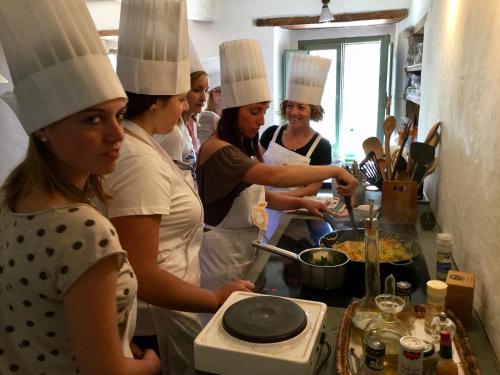 a group of people in a kitchen preparing food at Resort con vista nel Chianti Rufina in Londa