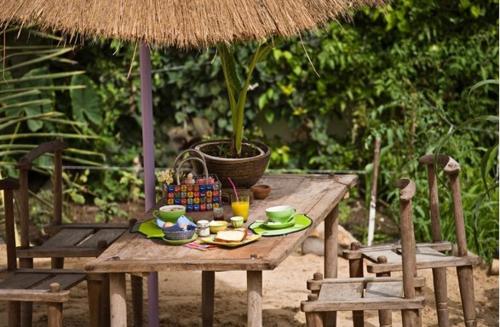 a wooden table with a plant on top of it at La Maison Abaka in Dakar