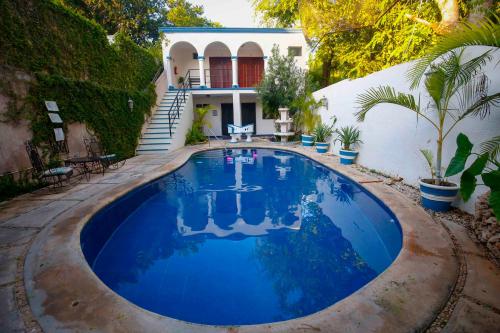 a swimming pool in front of a house at Hotel Zamna Boutique in Mérida