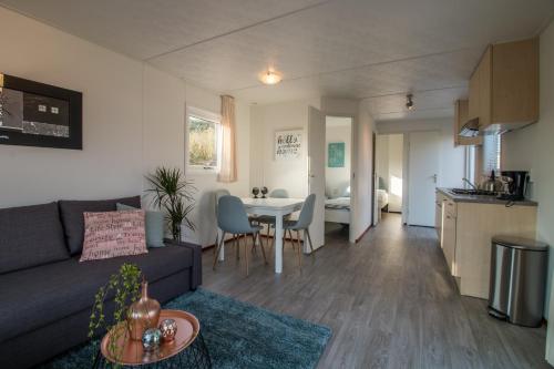 a living room with a couch and a table at CHALETS IN THE DUNES nearby the beach in IJmuiden