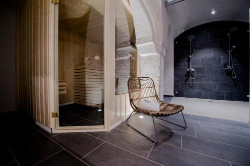 a chair sitting in a bathroom with a shower at Villa Weiss in Helmbrechts