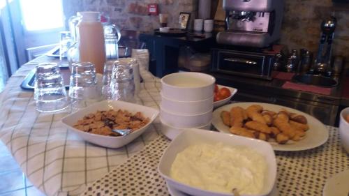 una mesa cubierta con tazones de comida en un mostrador en Oihalia Guesthouse, en Fidhákia