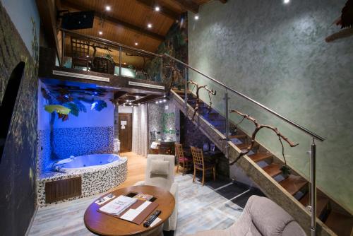 a room with a bath tub and a staircase and a table at Hotel SPA El Lagar de Isilla in La Vid y Barrios