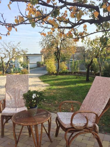 two chairs and a table on a patio at B&B Casa del Conte in Farra di Soligo