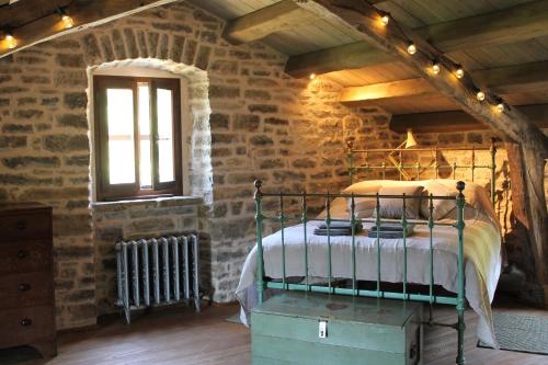 a bedroom with a bed in a stone wall at Bolara 60: the Cottage in Grožnjan