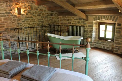 1 dormitorio con bañera en una pared de piedra en Bolara 60: the Cottage, en Grožnjan