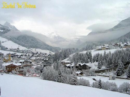 a town covered in snow with mountains in the background at Hotel De Fronz in Soraga