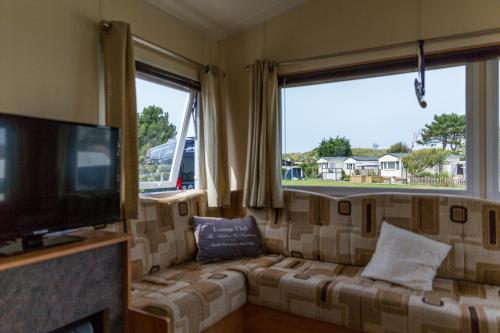 a living room with a couch and a flat screen tv at CHALETS IN THE DUNES nearby the beach in IJmuiden