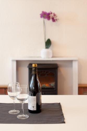a bottle of wine and two wine glasses on a table at MyCityHaven - The Chippings - Village life in the city in Bristol