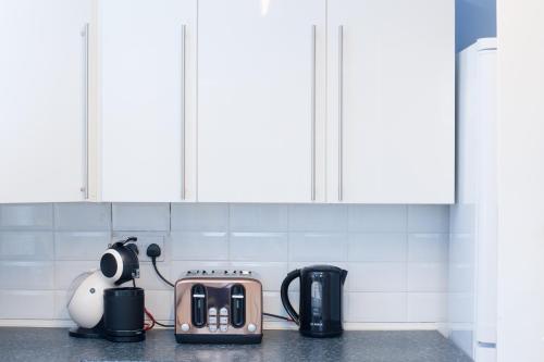 a kitchen counter with a toaster and a tea kettle at MyCityHaven - The Chippings - Village life in the city in Bristol
