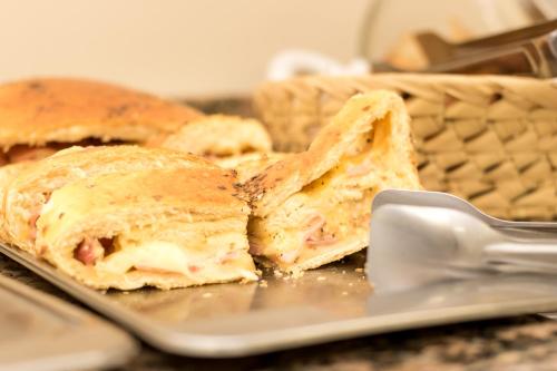 a sandwich cut in half on a plate with a spatula at Hotel Monte Carlo in Uruguaiana