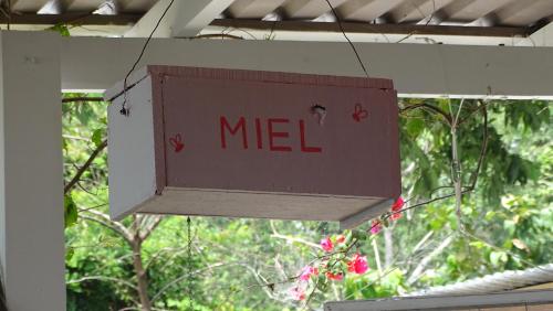 a sign that says miel hanging from a ceiling at La Colina Pura Vista in Bejuco
