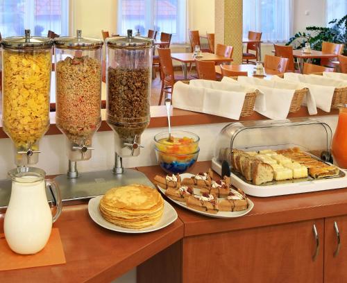 a breakfast buffet with pancakes and other food on a counter at Penzion Krumlov - Massage studio in Český Krumlov