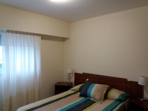 1 dormitorio con cama y ventana en Como en Casa 2 en Rosario