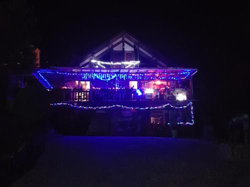 a house decorated with christmas lights in the dark at Le Nid Du Caveau in Ferrette
