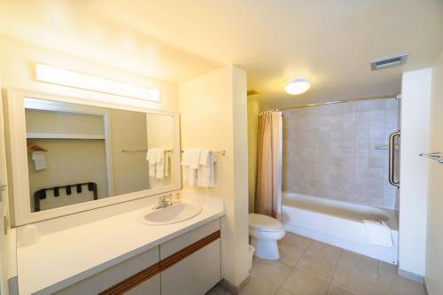 ein Badezimmer mit einem Waschbecken, einem WC und einem Spiegel in der Unterkunft The Sea Ranch Resort in Kill Devil Hills